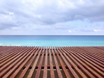 Scenic view of pier over sea against cloudy sky