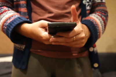 Midsection of man using mobile phone