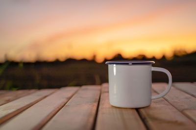 Close-up of coffee on table against orange sky