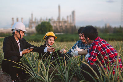 Young men with text on plant against sky