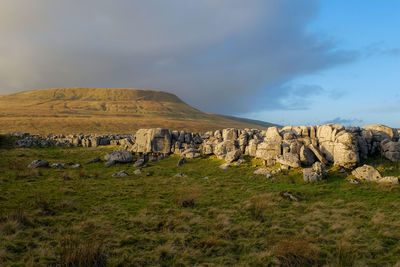 Scenic view of ingleborough and north yorkshire landscape against warm evening  sky