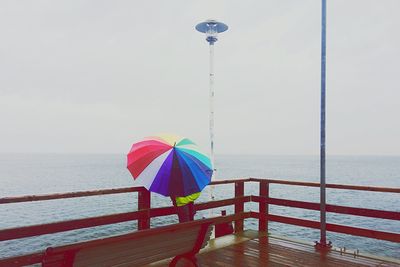 Multi colored umbrella on beach against sky