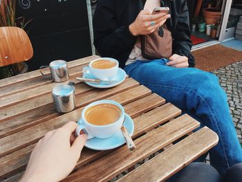 High angle view of woman holding coffee cup on table