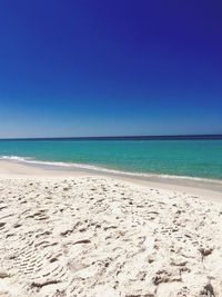 Scenic view of beach against clear blue sky