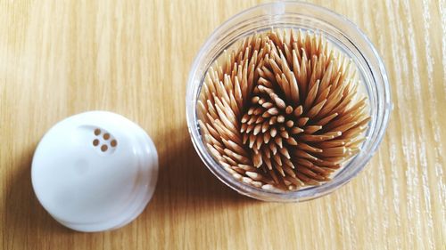 High angle view of toothpicks in container on table