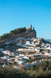 Buildings in town against clear blue sky