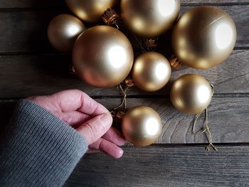 Cropped hand of woman holding baubles at table