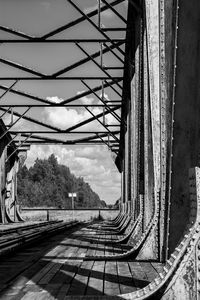 Bridge over railroad tracks against sky