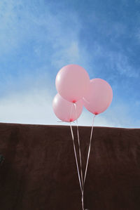 Low angle view of balloon against cloudy sky