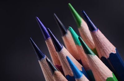 Close-up of colored pencils against black background