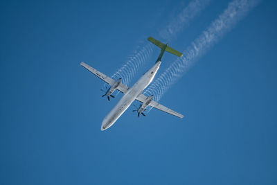 Low angle view of airplane against clear blue sky