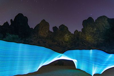 Scenic view of mountains against blue sky at night