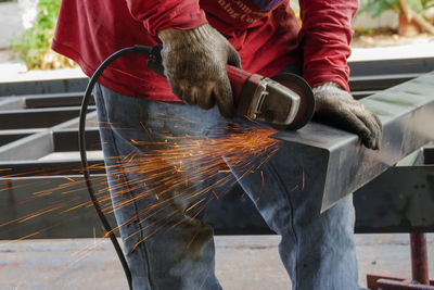 Low angle view of man working on metal structure