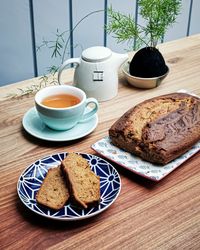 High angle view of tea on table with banana bread and kokedama plant