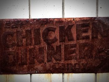 Close-up of rusty sign on wall
