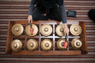 Midsection of women playing gamelan on floor