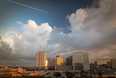 Modern buildings in city against sky during sunset