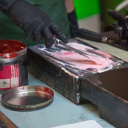 Midsection of man applying paint on wood