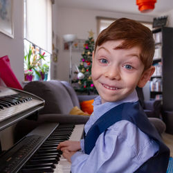 Portrait of boy smiling while playing the piano