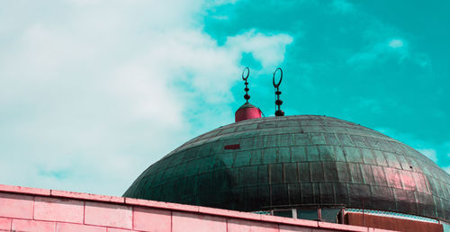 Low angle view of building against cloudy sky