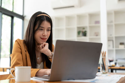 Young woman using laptop at table