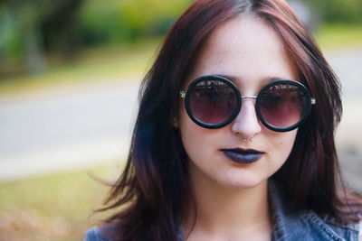 Close-up portrait of young woman wearing sunglasses