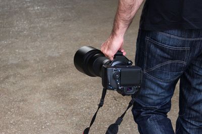 Midsection of man holding camera