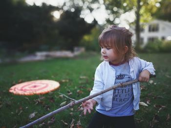 Girl looking at toy on field