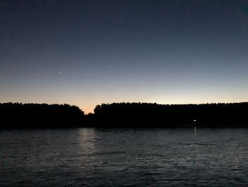 Scenic view of lake against clear sky during sunset