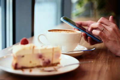 Woman have breakfast at cafe, use smartphone at cafe