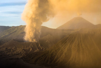 Smoke emitting from volcanic mountain against sky