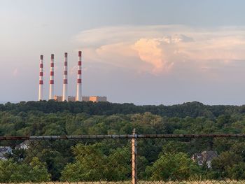 Built structure by factory against sky