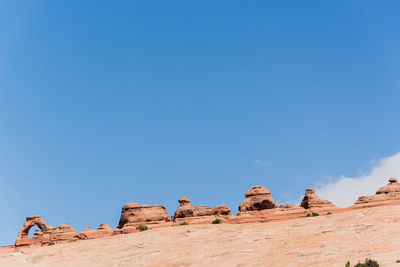 Low angle view of rocks against blue sky