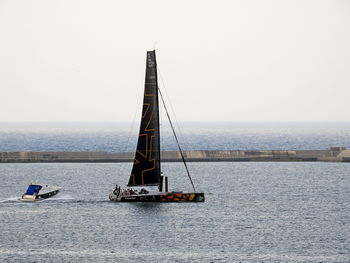 Sailboat sailing on sea against clear sky