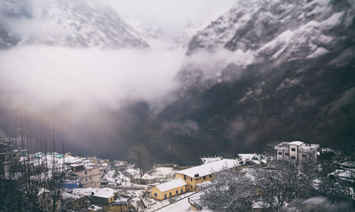 High angle view of houses by snowcapped mountains