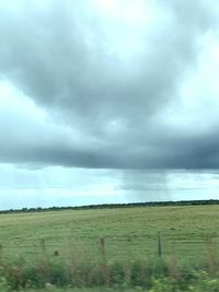 Scenic view of field against cloudy sky