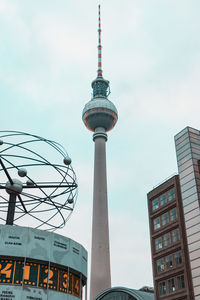 Low angle view of tv tower and buildings against sky