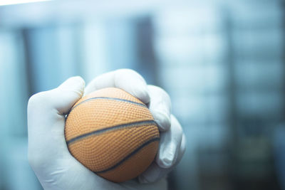 Close-up of hand holding sports ball 