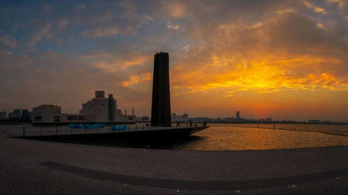 City buildings at waterfront during sunset