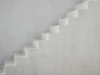 Empty steps by white wall