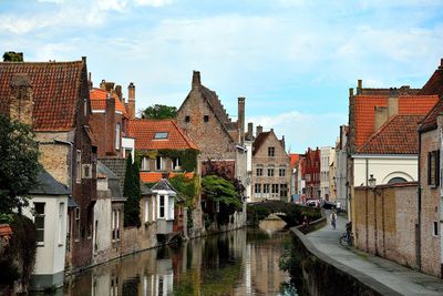 Canal amidst buildings in town against sky