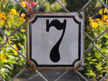 Close-up of black sign on metal fence