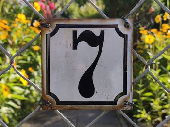 Close-up of black sign on metal fence