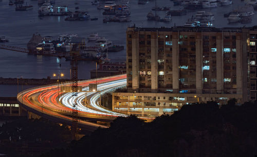 High angle view of light trails on street amidst buildings at night