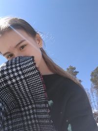 Portrait of teenage girl with scarf against clear blue sky