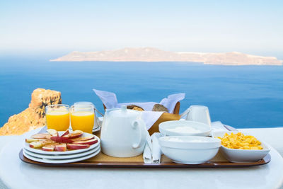 Food on table by sea against mountains