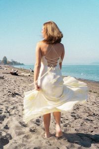 Rear view of woman standing at beach
