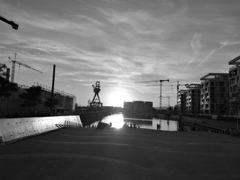 Street by canal against sky in city