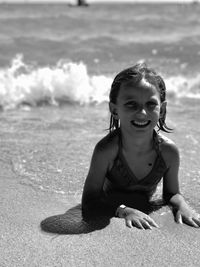 Portrait of young woman sitting at beach