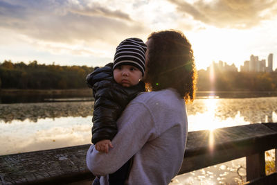 Side view of woman standing against railing